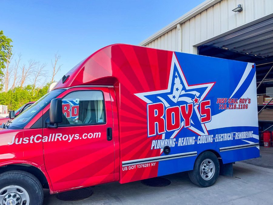 Red and blue Roy's Plumbing van with large star logo, parked outside a building; displays JustCallRoys.com and service areas (plumbing, heating, cooling, electrical, remodeling).