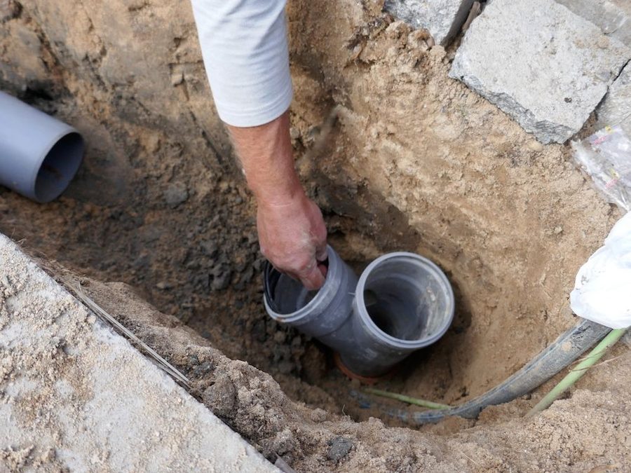 Plumber inspecting pipes underground during a sewer repair